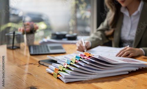 Business Documents concept : Businesswoman working in Stacks of paper files for searching and checking unfinished document achieves on folders papers.