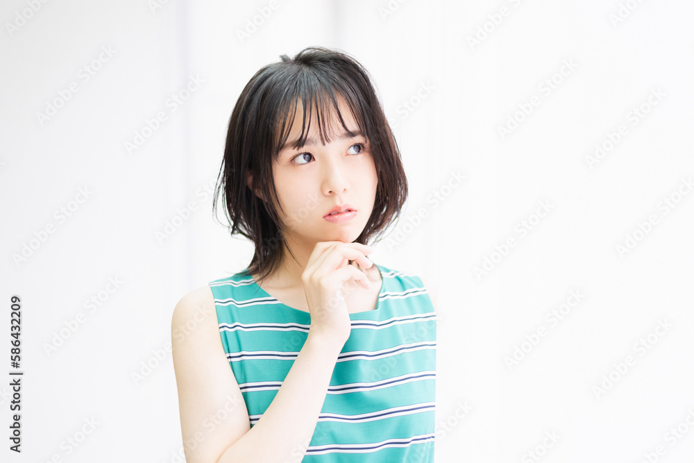 窓際に立ってこちらを見つめている若い女性 窓際に立ってこちらを見つめている若い女性
