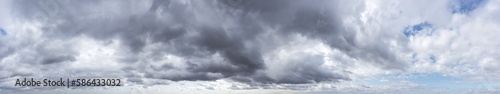 dramatic blue sky with dark gray clouds before rain. wide aerial panorama.
