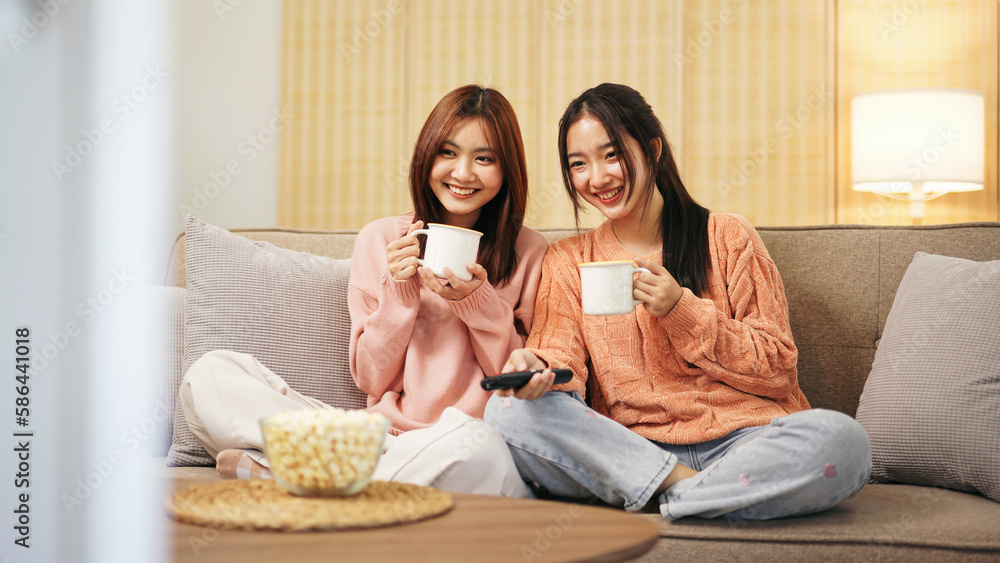 Young woman lesbian couple in sweater sitting on the comfortable