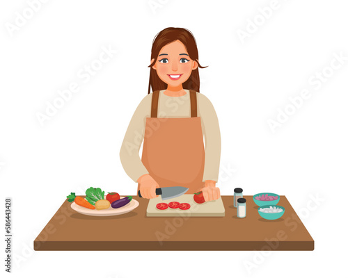Young woman cooking meal cutting slicing tomato vegetable with knife in the kitchen