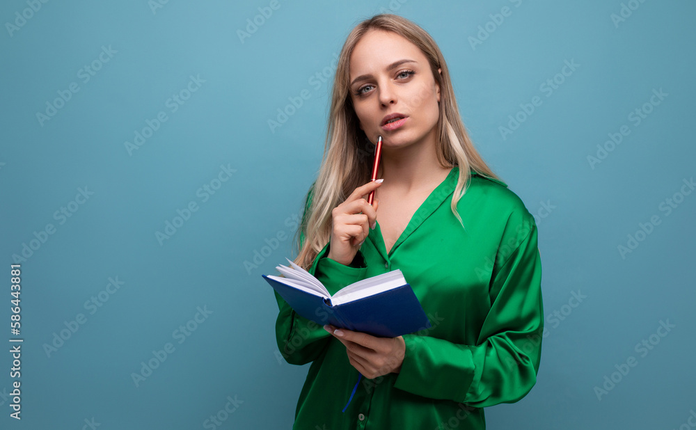 business lady freelancer thinking about work holding notepad and pencil on blue bright background business lady freelancer thinking about work holding notepad and pencil on blue bright background