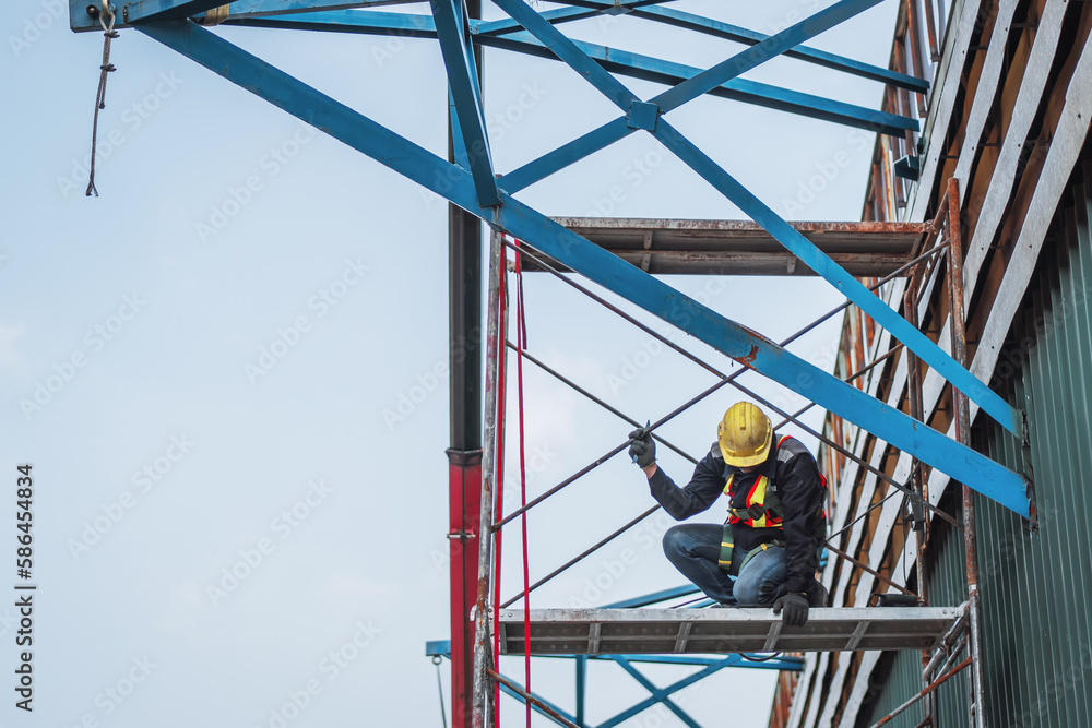 Construction worker wearing safety harnesses on Scaffolding at construction site. working at heights above ground ,Safe working for Scaffolding concept