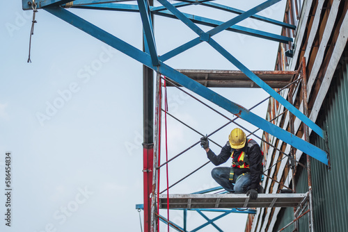 Construction worker wearing safety harnesses on Scaffolding at construction site. working at heights above ground ,Safe working for Scaffolding concept photo
