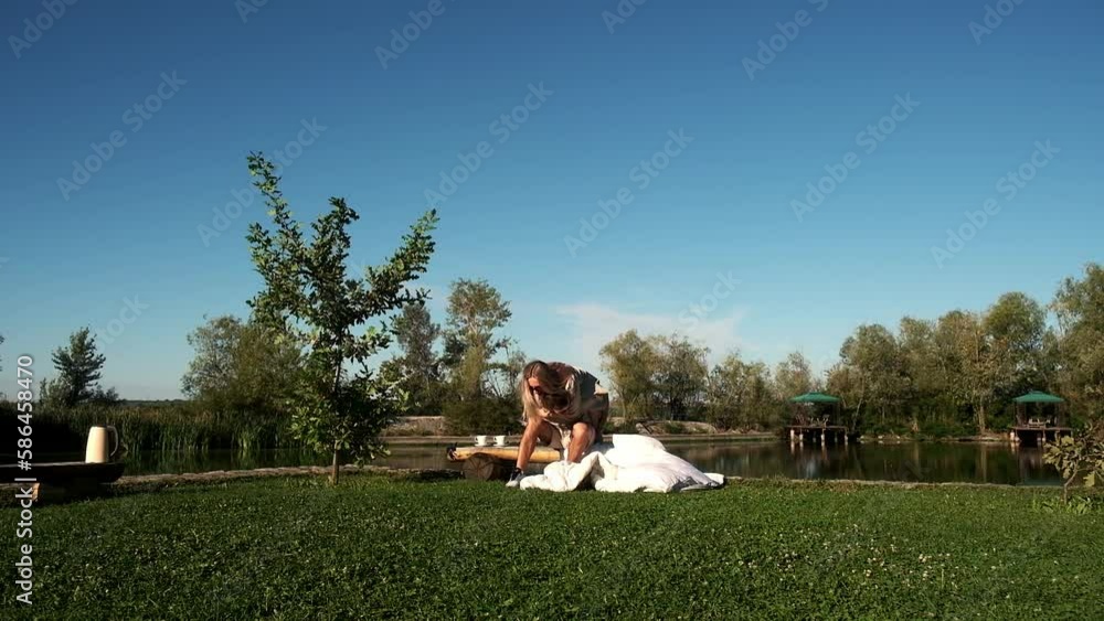 Happy smiling couple resting on the green grass. A park. Young family lying on the grass outdoors. Health care, freedom, love concept. Slow motion. Happy smiling couple resting on the green grass. A park. Young family lying on the grass outdoors. Health care, freedom, love concept. Slow motion.