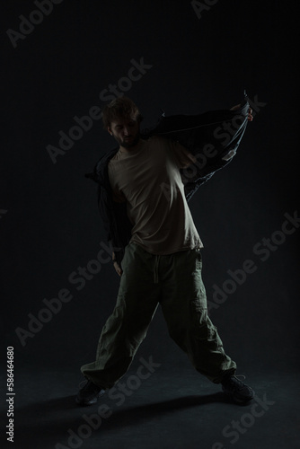 Fashion silhouette of a dancing stylish man in trendy clothes dancing in the dark © alones