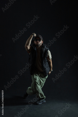 Cool fashionable man professional dancer in stylish clothes with sunglasses is dancing in the dark. Dancing man silhouette