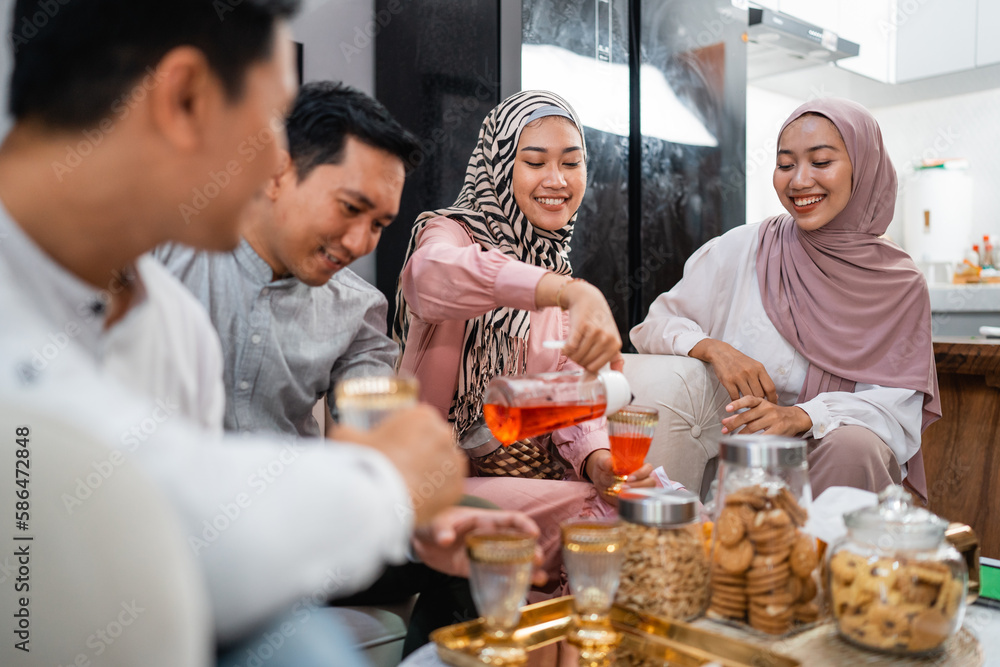 Muslim families get together while celebrating Idul Fitri cheering a glass at home Muslim families get together while celebrating Idul Fitri cheering a glass at home