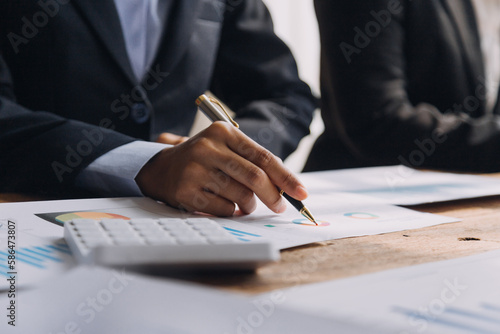 Financial analysts analyze business financial reports on a digital tablet planning investment project during a discussion at a meeting of corporate showing the results of their successful teamwork.