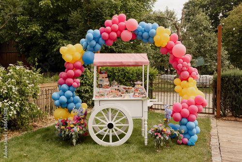 Bunte Candybar bei Hochzeitsfest im Garten mit Balloonwall photo