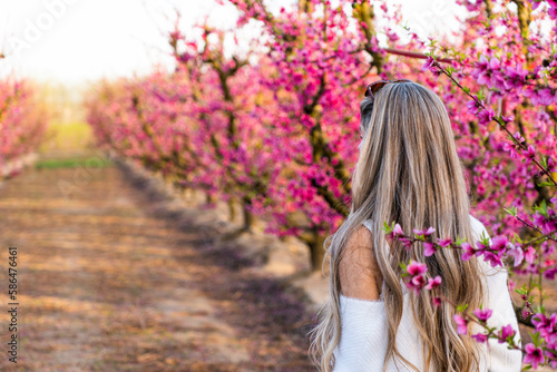 Rear view of blonde woman in a field of pink flowers in Aitona in spring photo