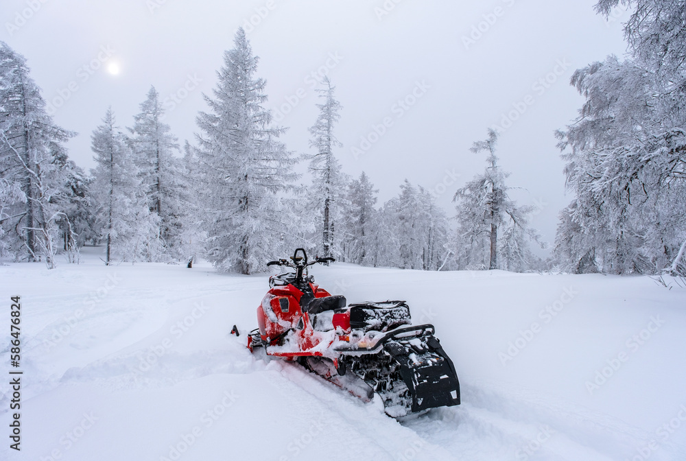 Snow-covered snowmobile in the winter forest in the mountains of the Southern Urals