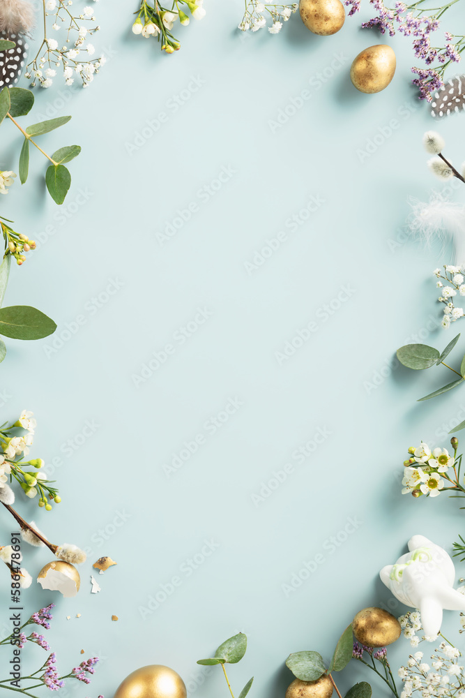 Happy Easter concept with golden easter eggs, feathers and spring flowers. Easter background with copy space. Flat lay