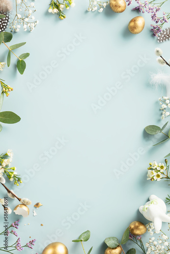 Happy Easter concept with golden easter eggs, feathers and spring flowers. Easter background with copy space. Flat lay