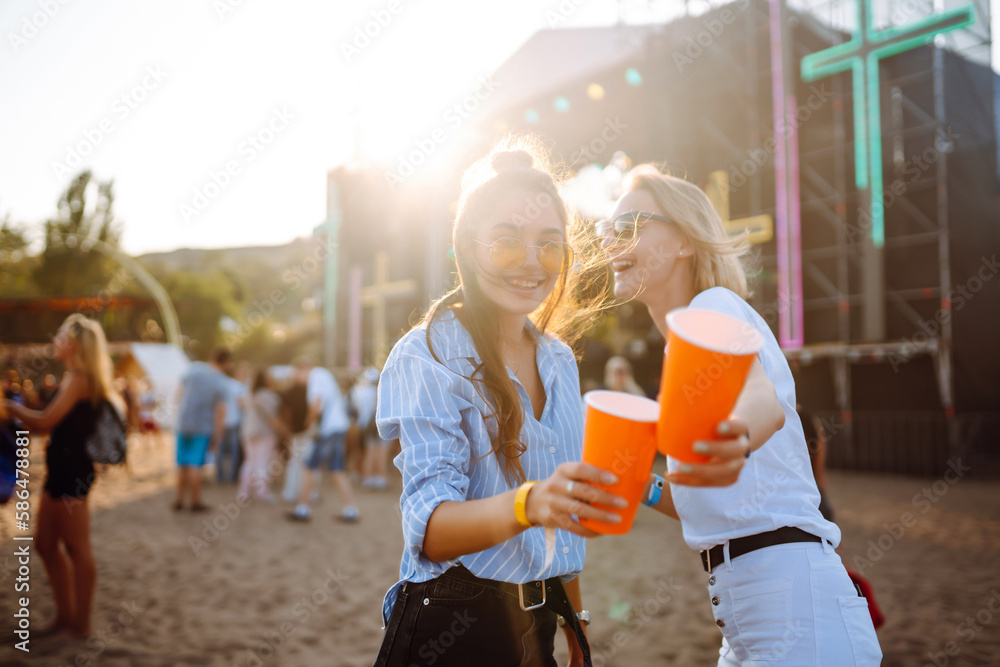 Two young woman  with beer at music festival. Beach party, summer holiday