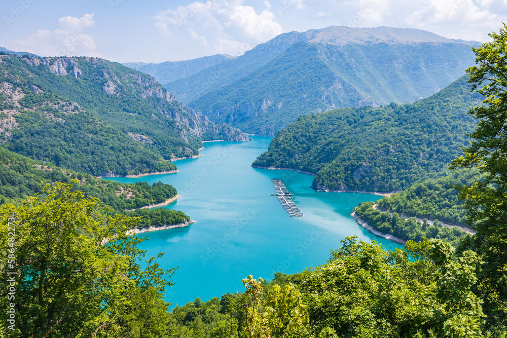 Aerial view of Piva lake or Pivsko Jezero between hills covered with green trees