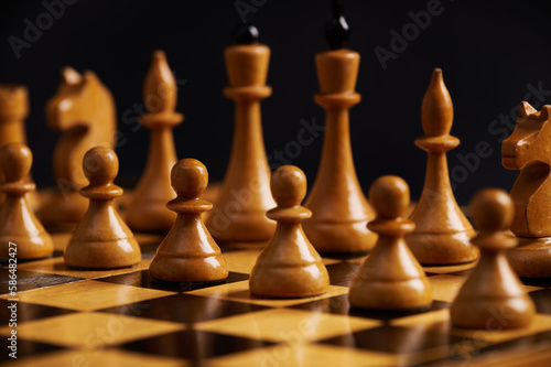 White chess pieces standing in start positions on the chessboard  over isolated black background. Chess developing leadership   business strategy  risks. The concept of war  destruction and winning