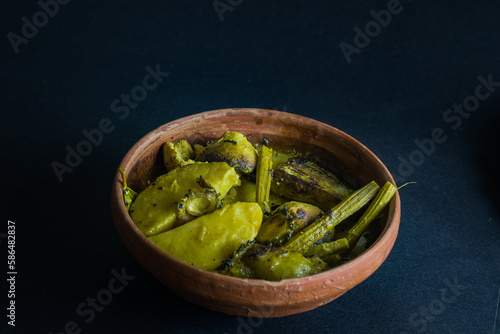 Shukto is a traditional vegetarian Bengali dish which has a slightly bitter taste. It is made of different vegetables and milk and served with rice in summer seasons. Photo taken in dark background. photo