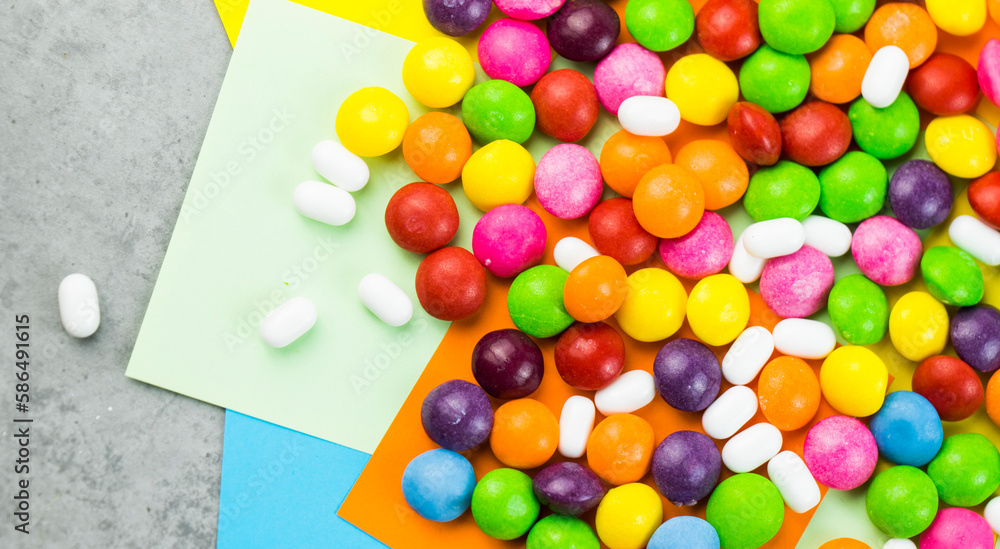 Obraz premium Skittles candy on the colorful table, colorful sweet candy