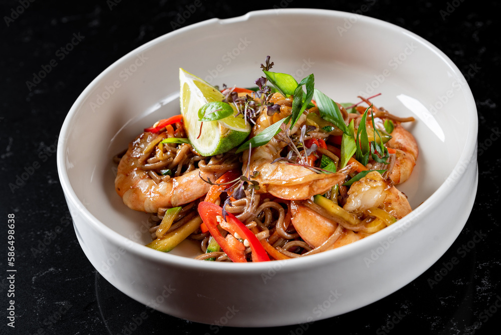Stir fry noodles with vegetables and shrimps in plate on table background Stir fry noodles with vegetables and shrimps in plate on table background