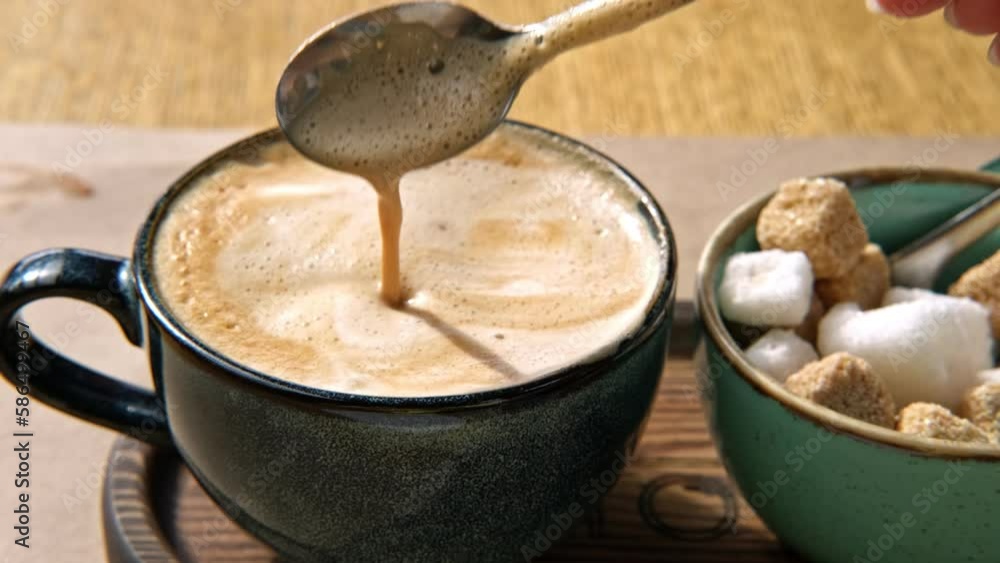 Person Mixing Cappuccino Foam in Blue Ceramic Cup on Wooden Cafe Table. Stirring Latte Thick Froth with Spoon, Trendy Authentic Modern Porcelain Set. Pottery Handmade Coffee Mug Served with Sugar Bowl Person Mixing Cappuccino Foam in Blue Ceramic Cup on Wooden Cafe Table. Stirring Latte Thick Froth with Spoon, Trendy Authentic Modern Porcelain Set. Pottery Handmade Coffee Mug Served with Sugar Bowl