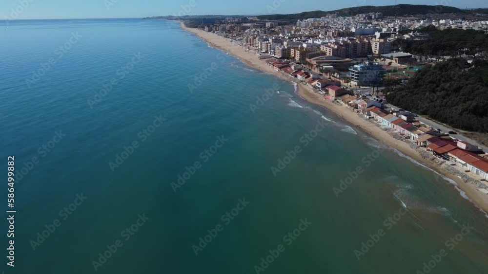 Drone descending over Mediterranean sea towards Guardamar del Segura waterfront sunny coast