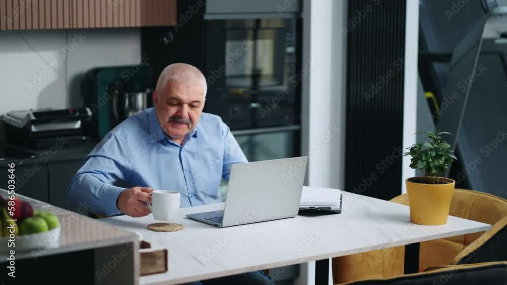 Home Office Of Senior Man Working With Laptop In Kitchen, Portrait Of Aged Person In Workplace Home Office Of Senior Man Working With Laptop In Kitchen, Portrait Of Aged Person In Workplace
