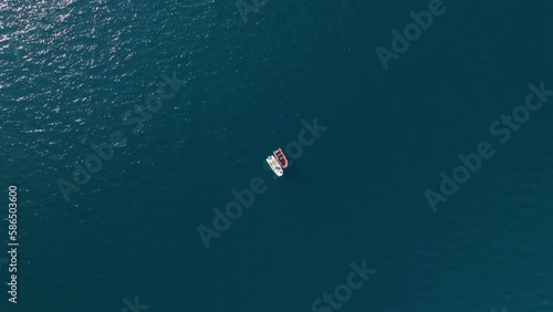 Aerial drone tracking video of red boat cruising in high speed in Mediterranean sea photo