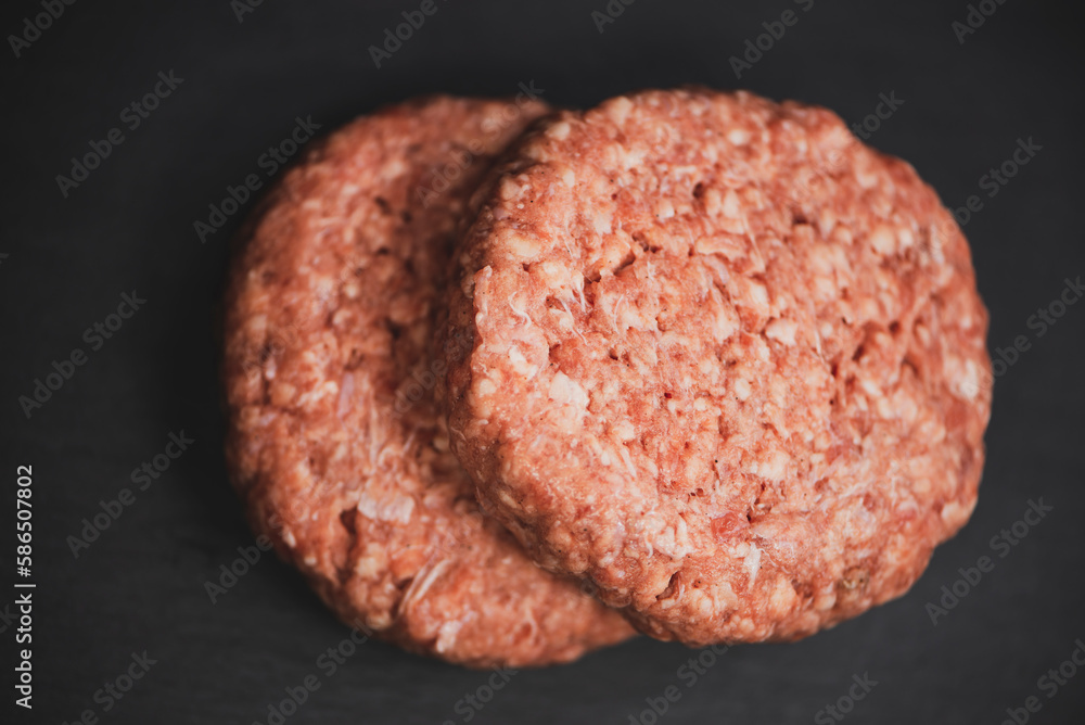 raw beef cutlet for cooking burger on a dark background raw beef cutlet for cooking burger on a dark background