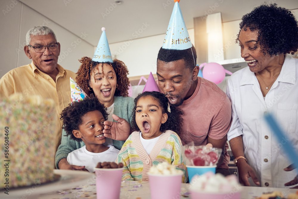 Fototapeta premium Birthday party, food and surprise with family in kitchen for celebration, bonding and affectionate. Happy, excited and grandparents with parents and child at home for generations, fun or event