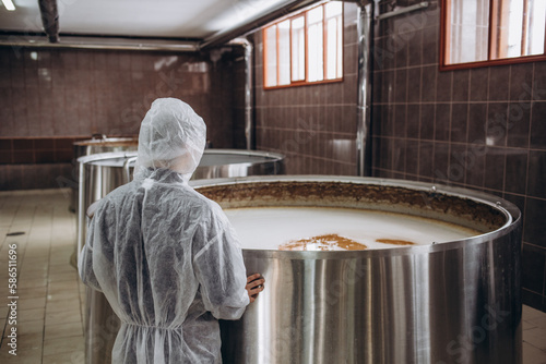Tableau sur toile Handsome bearded brewer controlling beer fermentation process at his craft beer