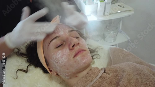 Acne treatment of problematic face skin with ozone facial steamer in spa or dermatology center. Steam for smooth skin and open pores before applying face mask photo