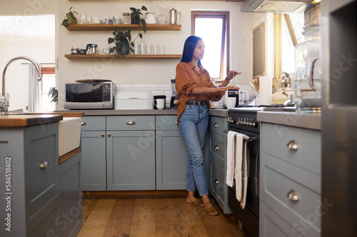 Kitchen, thinking and woman prepare coffee for breakfast latte, cappuccino and hot beverage at home. Relaxation, calm morning and thoughtful girl make espresso, caffeine drink and brewing for peace photo