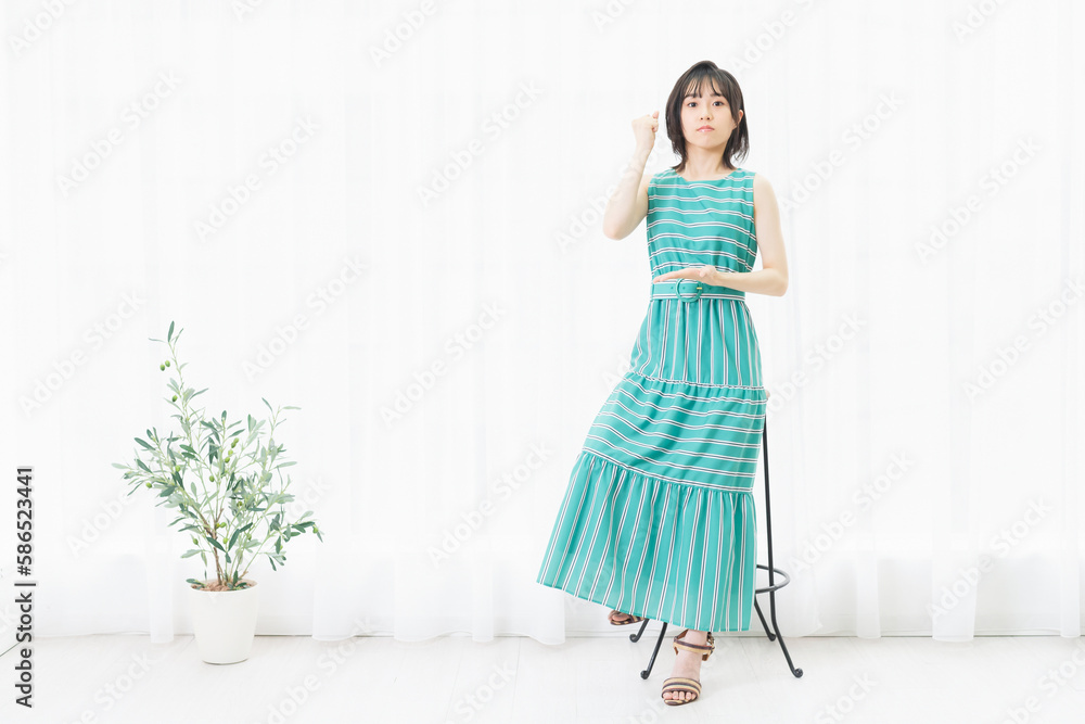 窓際で納得したポーズをする若い女性 窓際で納得したポーズをする若い女性