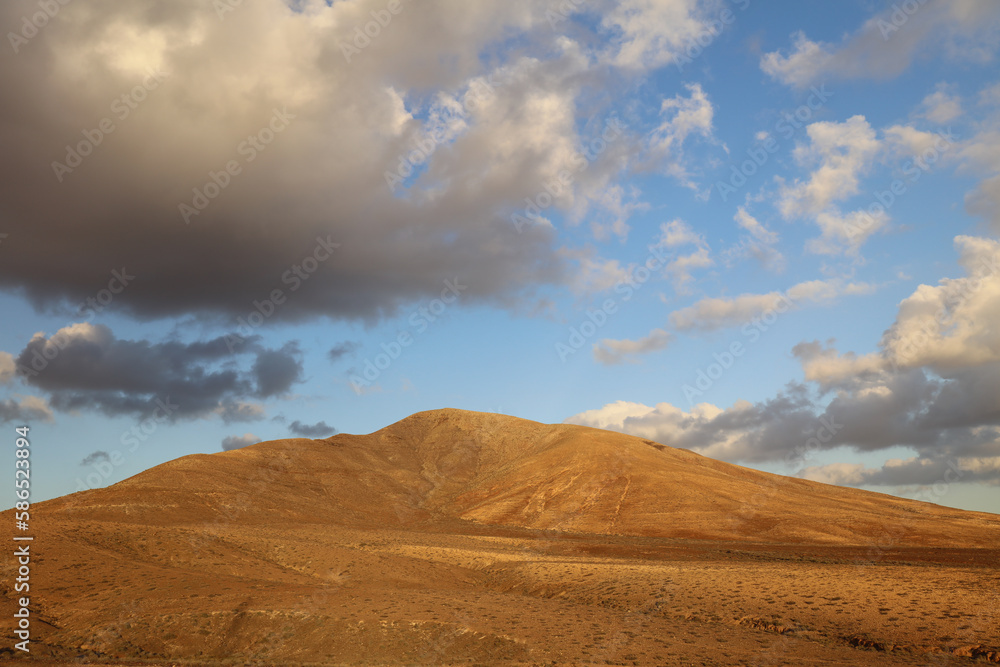 Panoramic view of arid climate in a desert land in Fuerteventura at the sunset. Panoramic view of arid climate in a desert land in Fuerteventura at the sunset.