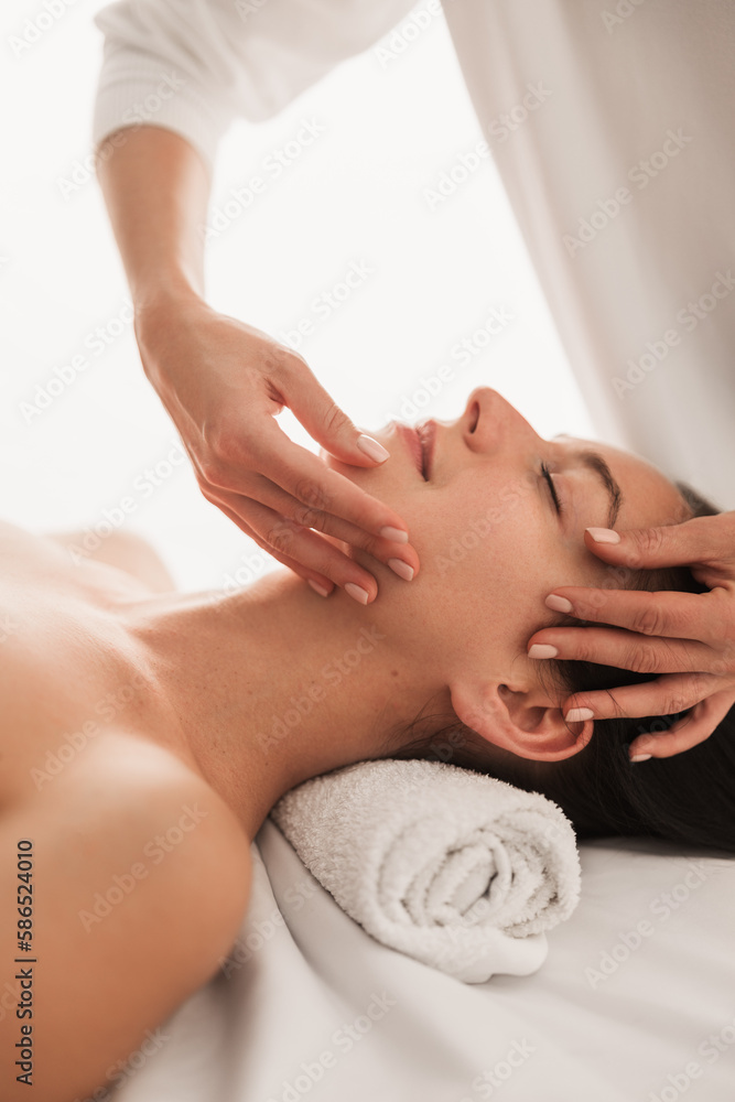 Naklejka premium Massage therapist massaging face of client in beauty clinic