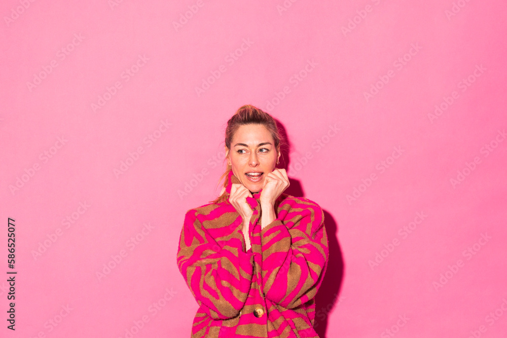 Woman wearing overcoat against pink background Woman wearing overcoat against pink background