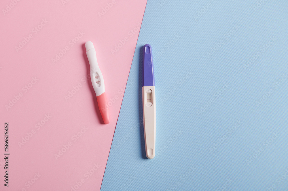 Pregnacy tests with positive reults, isolated over bicolor pink and blue background. Planning maternity concept. Women's health and fertility concept. Rapid diagnosis of pregnancy at home. Flat lay Pregnacy tests with positive reults, isolated over bicolor pink and blue background. Planning maternity concept. Women's health and fertility concept. Rapid diagnosis of pregnancy at home. Flat lay