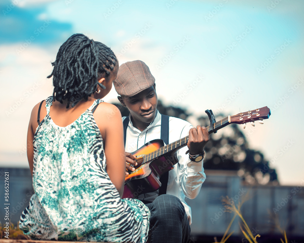 A man playing a guitar for a Lady. Love is a beautiful thing
