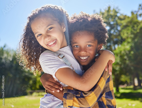 Portrait, kids and friends hugging in a park together for fun, bonding or playing in summer. Hug, children or diversity with girl and boy best friends embracing in a garden during the day
