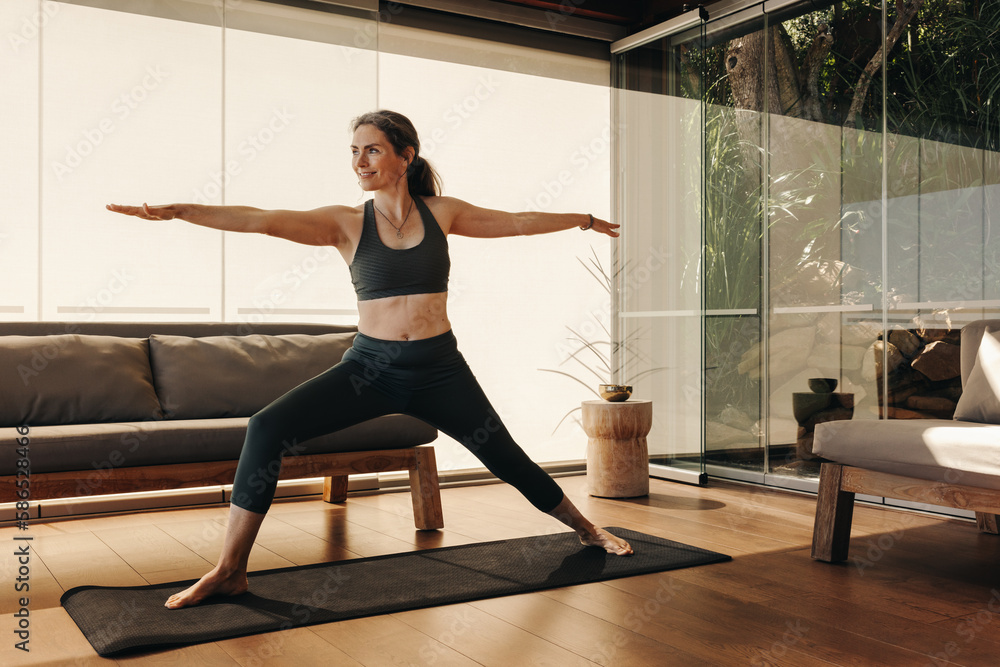Mature woman doing the warrior pose during yoga Mature woman doing the warrior pose during yoga