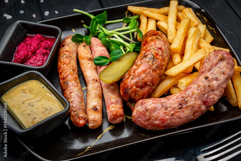 Different sausages in a pan with fried potatoes