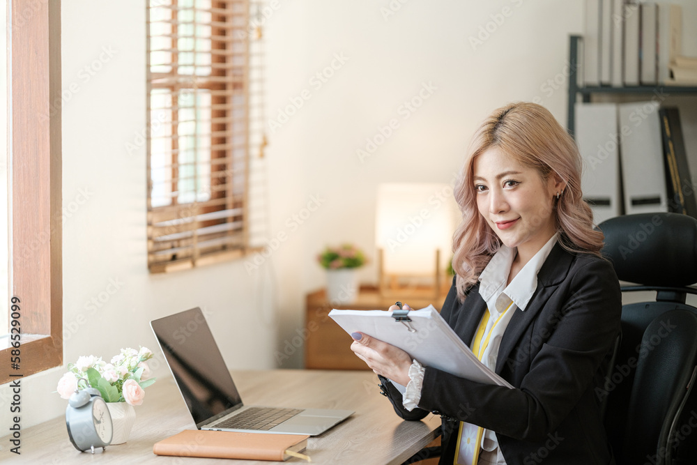 Close up on laptop in office, Asian happy beautiful businesswoman in formal suit work in workplace. Attractive female employee office worker smile. Close up on laptop in office, Asian happy beautiful businesswoman in formal suit work in workplace. Attractive female employee office worker smile.