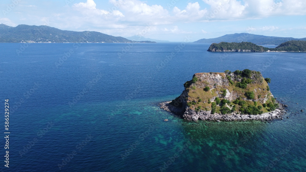 Small tropical island in the middle of the sea. Aerial view of an island in the ocean.