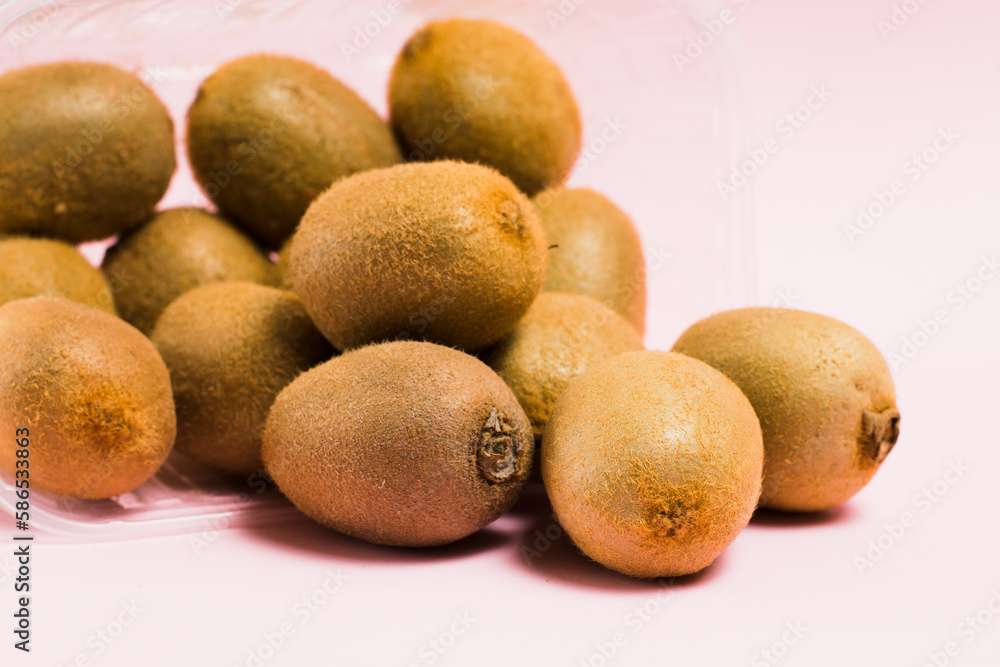 Kiwi in plastic packaging on a pink background. Concept of earth day, zero waste and recycling. Kiwi in plastic packaging on a pink background. Concept of earth day, zero waste and recycling.