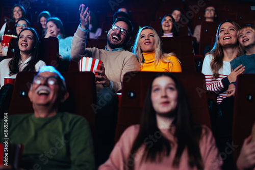 Cheerful couple enjoy movie in cinema.