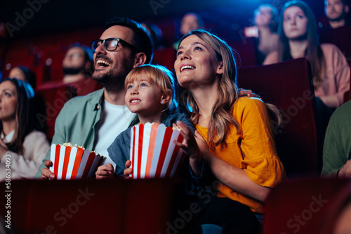 Joyful family watching movie in cinema. photo