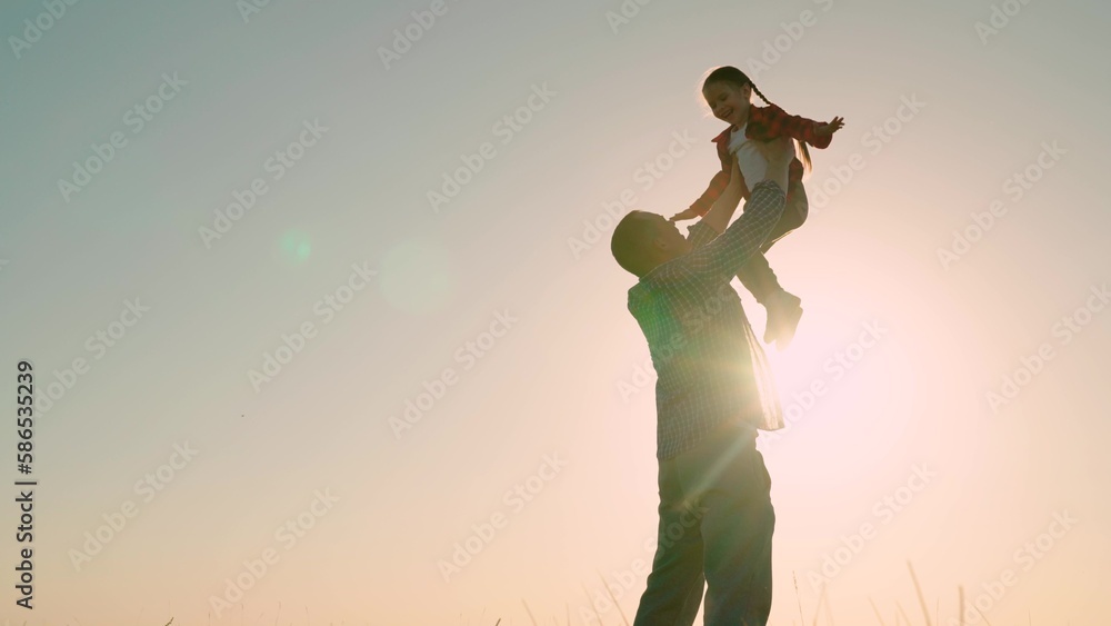 Happy family concept, childhood dream to fly. Dad kid. Father throws happy baby daughter into sky. Family game with child. Dad is playing with child in park, son dreams of flying and being pilot.