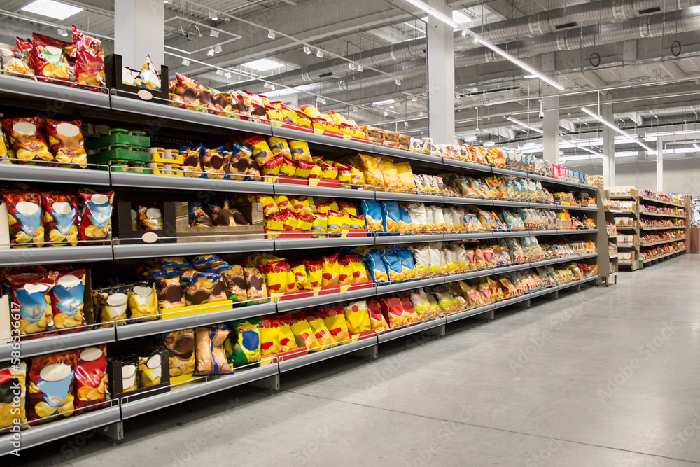 Fototapeta premium Chips and snacks on shelf at supermarket, suitable for mockup and new graphic design packagings solutions.