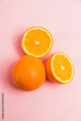 Juicy pieces of orange on a pink background. Delicious fruit on a bright background.